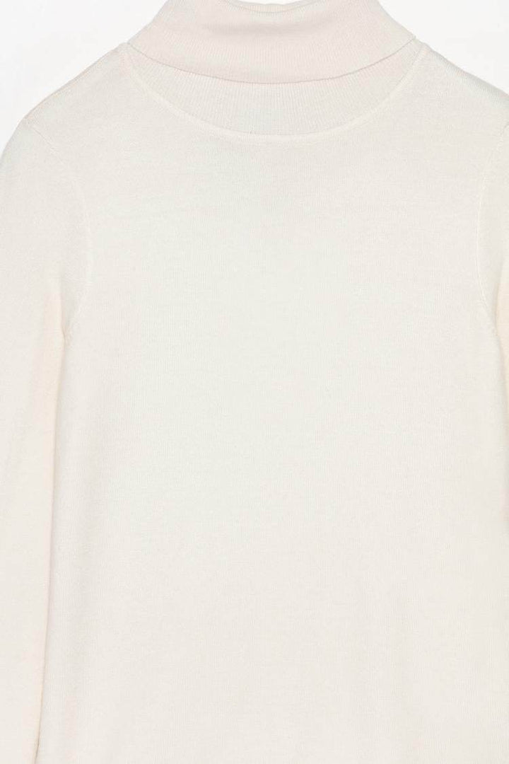 Close-up product image of white turtleneck sweater

