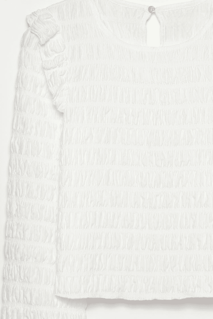 Close-up product image of white ruffle blouse fabric

