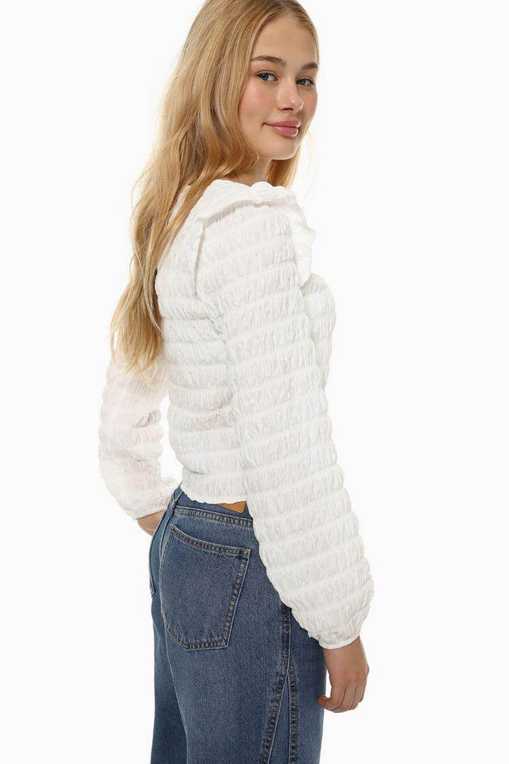 Side view of the women's white ruffle blouse

