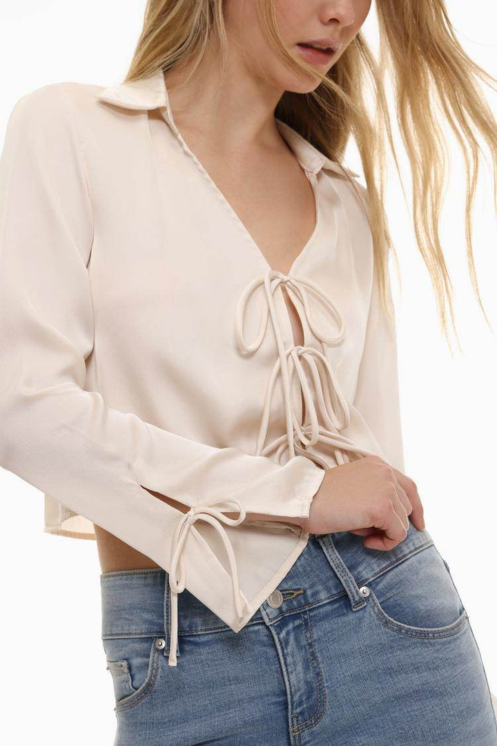 Model showcasing front of white satin shirt with ties

