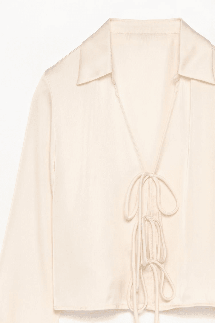 Close-up product image of white satin shirt fabric

