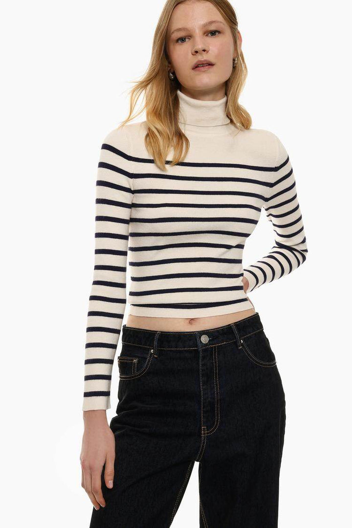 Model showcasing white turtleneck sweater front

